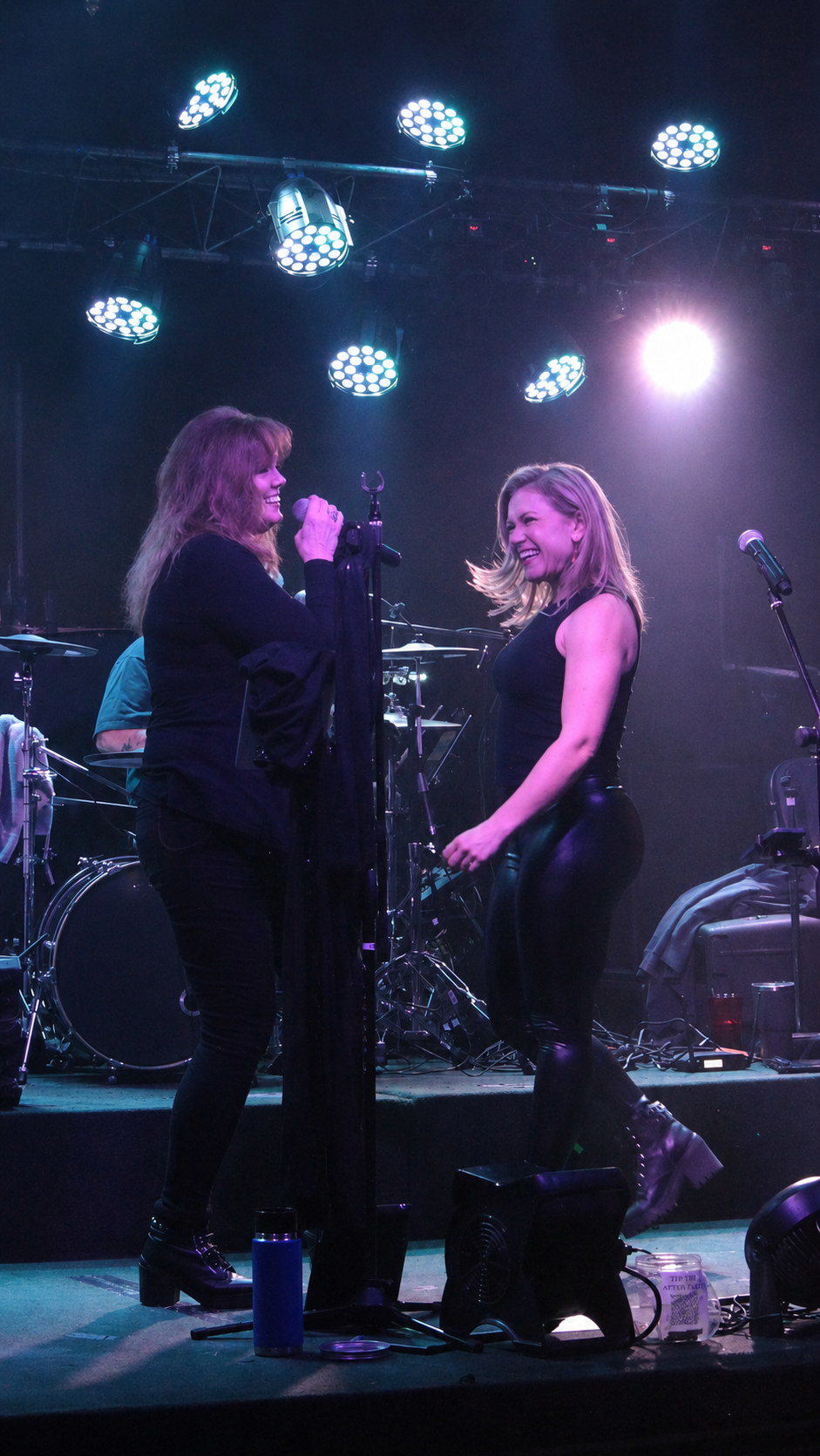 Joan and Christa sharing a lighthearted moment on stage