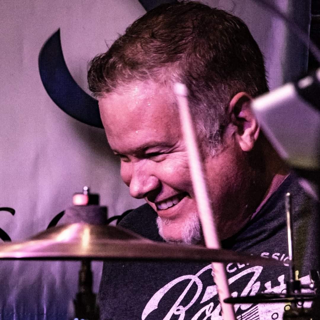 Mark smiling behind the drums